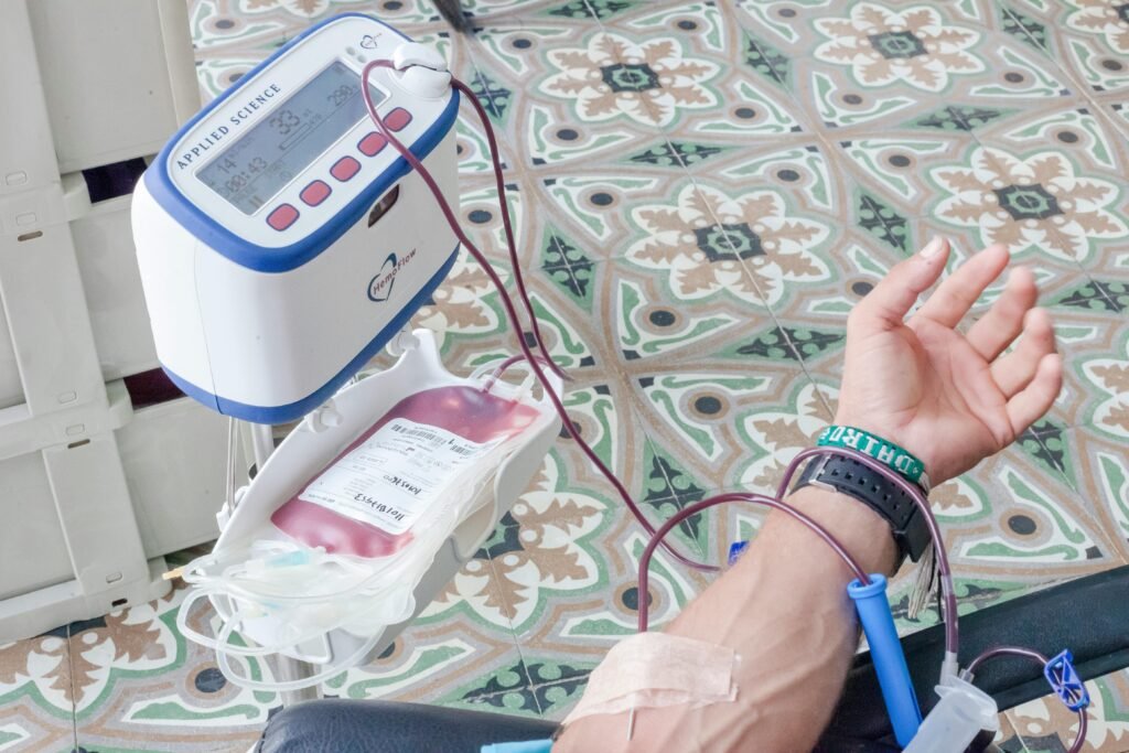 Close-up of a patient's arm during blood donation with medical equipment.
