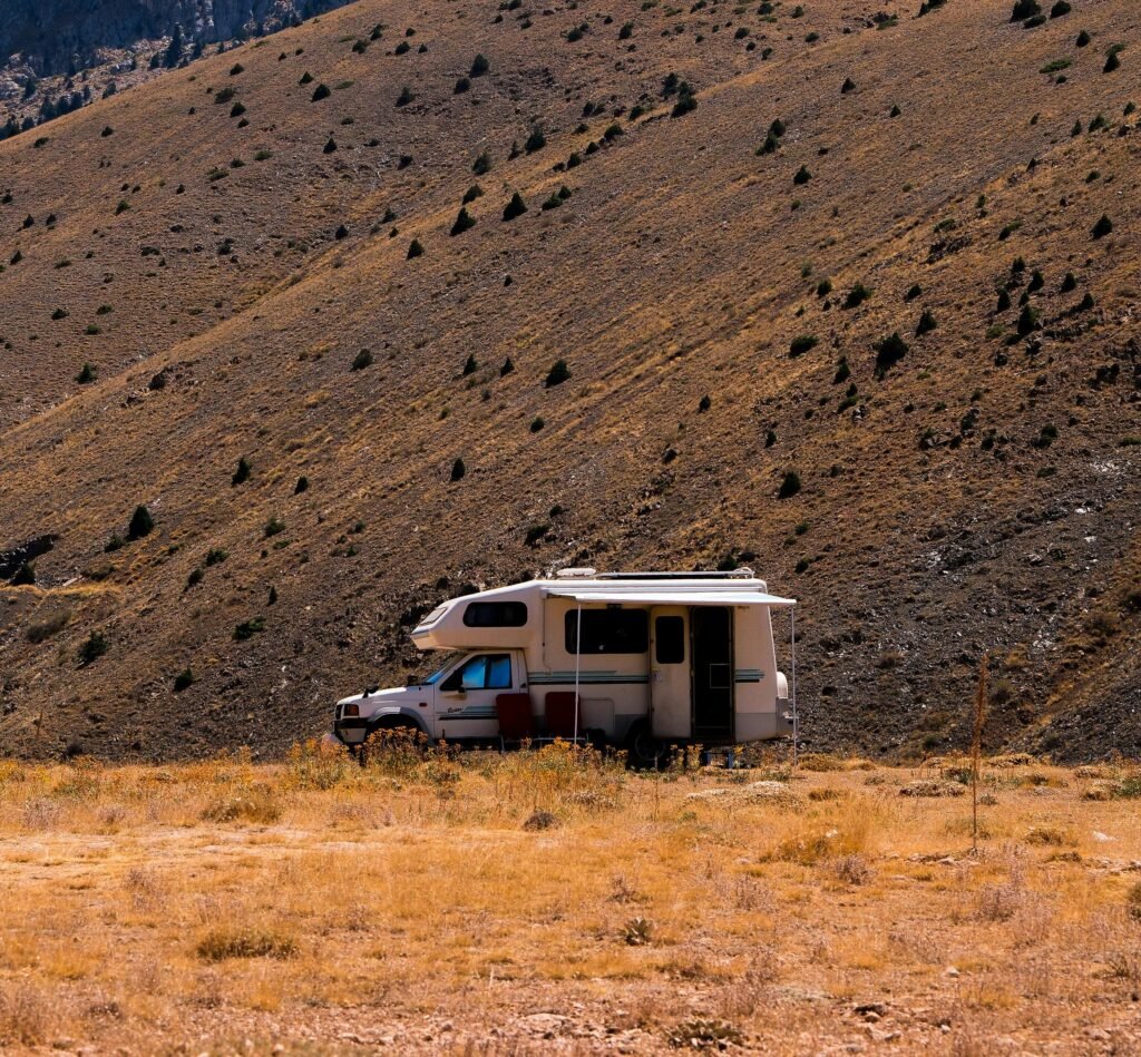 A solitary camper van in a dry desert landscape, ideal for adventure travel.