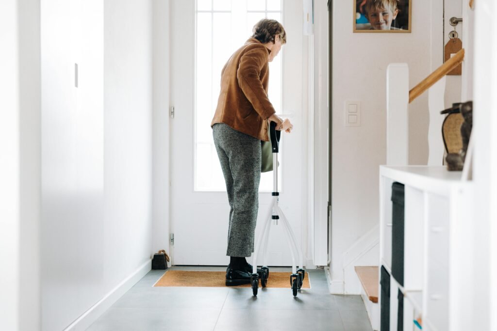 Senior adult using a rollator indoors, embracing mobility aid with confidence.